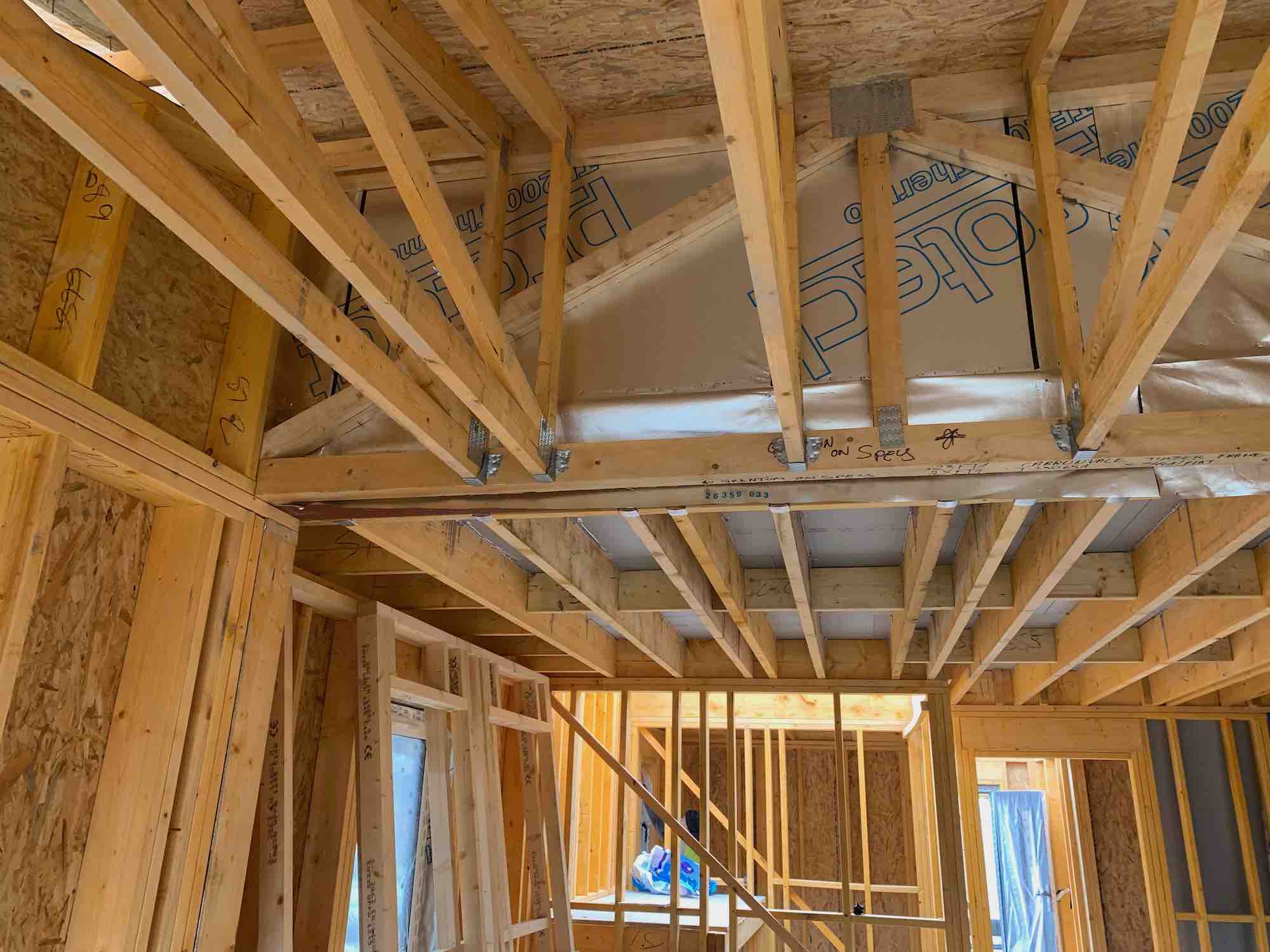 Internal photo of errected timber frame showing mid-floor, trusses, internal and external walls